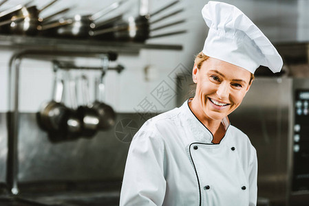 身穿制服和帽子的漂亮女厨师在餐厅厨房用复印图片