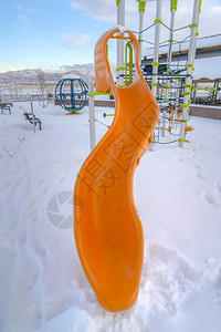 在白雪皑的游乐场滑梯和攀爬架图片