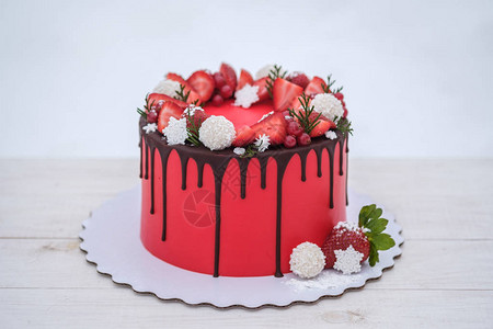 美丽的自制红色蛋糕与白色背景上的新鲜草莓浆果图片