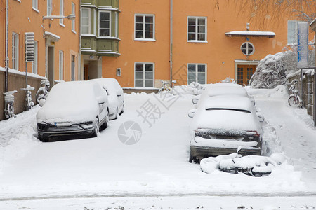 许多停着的汽车被雪覆盖图片
