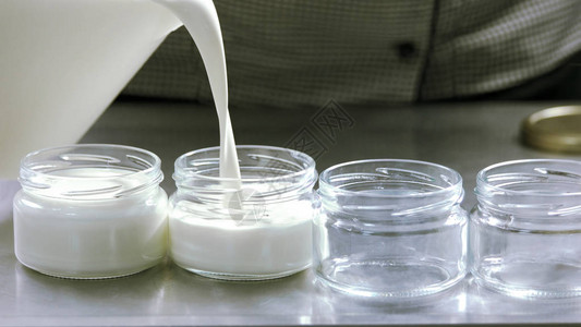 牛奶倒入玻璃容器在家做酸奶制备过程有机奶制品生图片