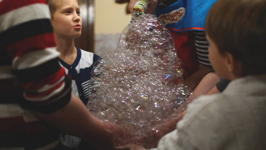 孩子们把肥皂泡沫堆积在背景图片