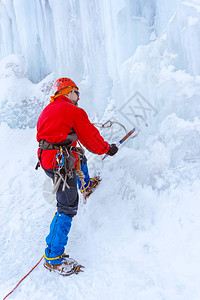 用冰斧切冰的岩石攀岩者在冰川中踏步图片