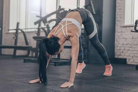 黑头发适合的女运动员在健身房锻炼前伸展她的身体图片