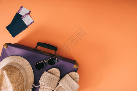 挂有护照和橙色背景机票的旅行袋中夏季附图片