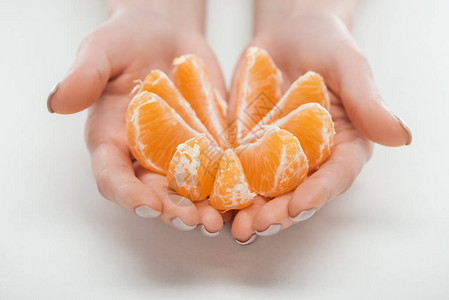 白色背景圆成一圈的持有成熟橙橘色子切片的妇图片