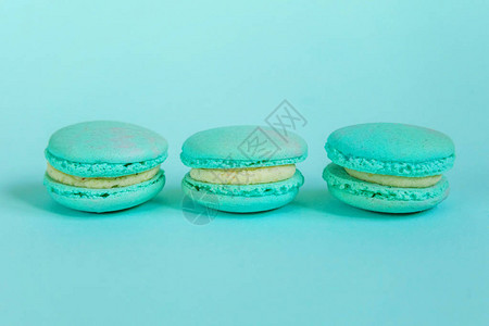甜杏仁五颜六色的独角兽蓝色马卡龙或马卡龙甜点蛋糕隔离在时尚的蓝色柔和背景法国甜饼干最小的食品烘焙概背景图片