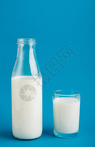 蓝底的奶瓶和牛奶杯钙和蛋图片