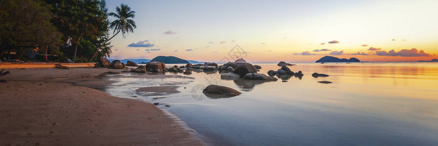 海日落岩石海滩在蓝天背景美丽傍晚日出蓝色背景图片
