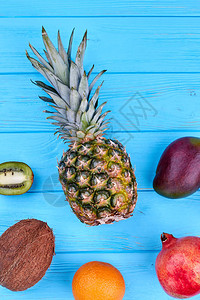 新鲜椰子菠萝基维果橙色石榴和蓝木本底芒果的平坦杂质背景图片