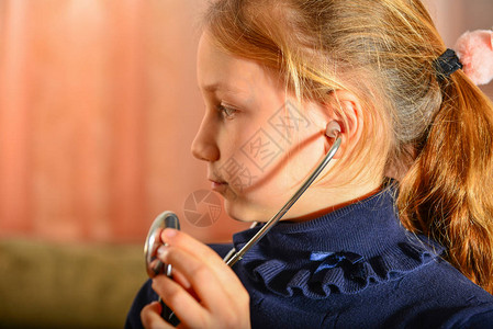 女孩手里握着听诊器听病人讲话在医生图片