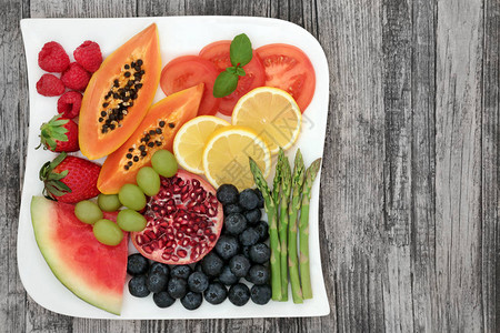 健康食品节食和减肥与新鲜蔬菜和水果在质朴的木质背景上的方形盘子富含花青素膳食纤维抗氧化剂和背景图片