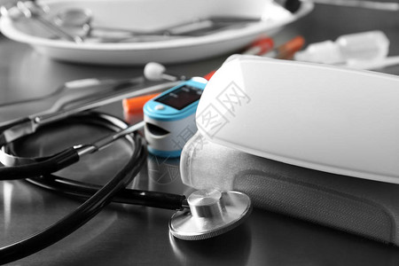 灰色桌子上的血压计听诊器和血压监测背景