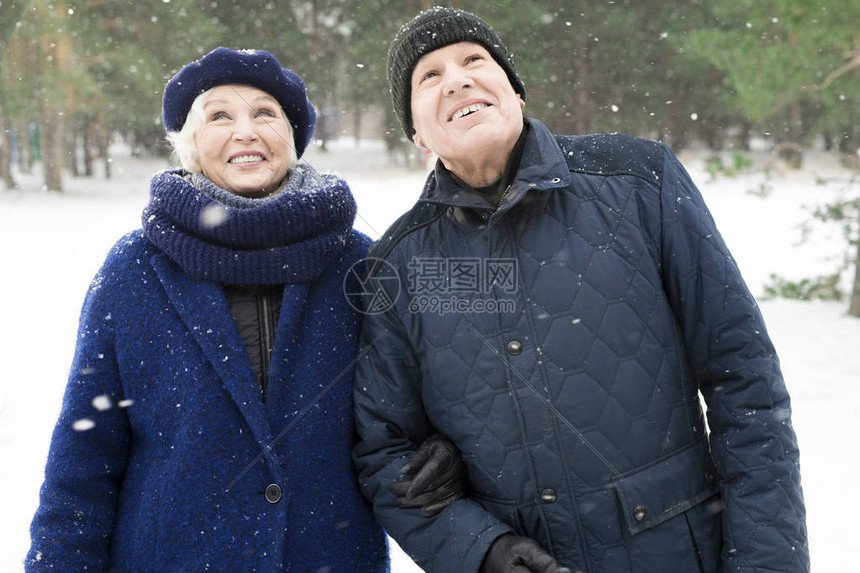 喜悦的老年夫妇在冬季中行走图片
