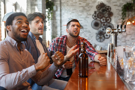 足球迷在酒吧看比赛和喝啤酒图片