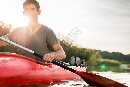 阳光落在湖面上划皮艇的男人脸上图片