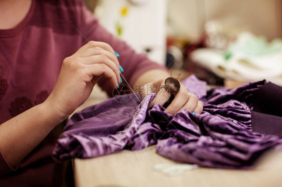 女在裁缝工场用针头缝衣服图片