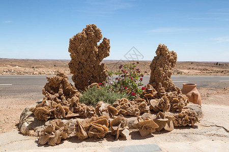 突尼斯沙漠道路旁的花坛上的大沙漠玫瑰石图片