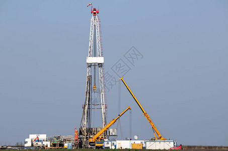 油田行业的陆地石油钻机和起重机背景图片