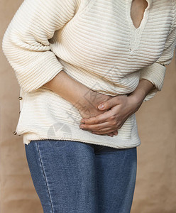 有痛苦的胃痛的少妇慢胃炎腹胀和保健概念痛苦的月经天的概念用手捂背景图片
