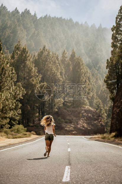 年轻的金发女郎穿着人字拖在阿甘沿线空荡的路上奔跑夏季时间生活方式跟着我从后面查看假期运动和灵图片