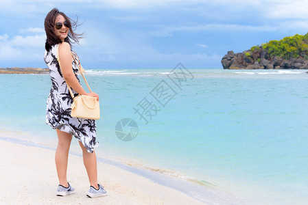 夏空海滩和海的风景与喜悦的女游客身着太阳眼镜图片