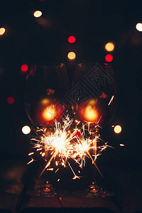 烟花闪亮的孟加拉火花在黑色背景和酒杯上燃起火焰背景