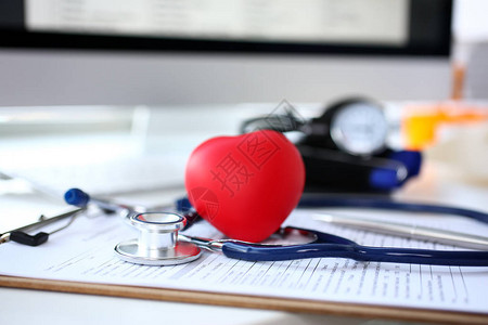 位于医生办公室工作台医疗申请表上的静脉透视镜头和红心形玩具心血管治疗师心脏生理体格检查心律失常和紧急复图片
