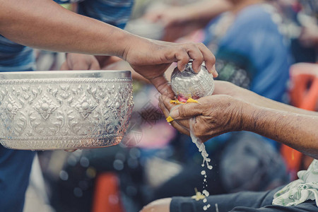 泰国人通过浇水和花环给长辈或尊敬的祖父母和长辈庆祝泼水节背景图片
