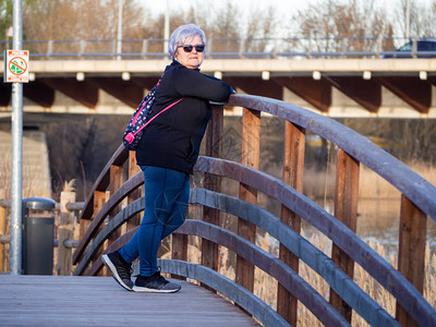 一名身着白头发的老年妇女在木桥上图片