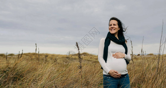 孕妇在田里爱抚她的肚子图片