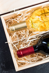 红酒和白酒瓶装在旧木箱图片