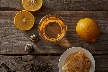 天花茶在玻璃柠檬和木制桌上的图片