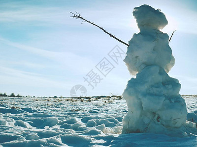 站在冬天风景的真正的冰冷雪人炎热的春天太阳和一些人在图片