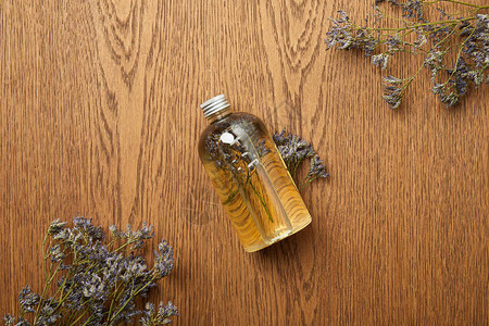 透明瓶子的顶部视图天然美容产品靠近木背景图片