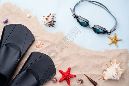 用贝壳和海星在沙滩上游泳的护目镜和脚踏板图片