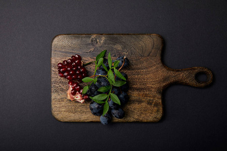 黑色表面木板上的葡萄和加背景图片