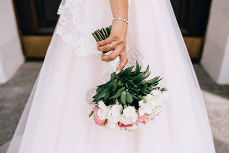 新娘拿着一束婚礼花束白色和硅色调的图片
