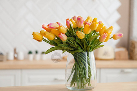 一束新鲜的春天黄色郁金香的特写镜头在一个摄影工作室的一个大透明玻璃花瓶中图片