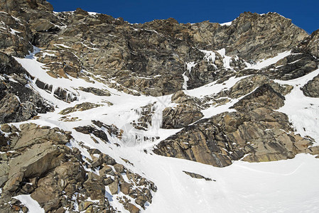 崎岖的高山岩石山腰结冰的被冰雪覆盖图片