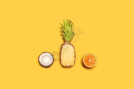 黄底热带果汁在夏季的创意构成橙子椰子背景图片