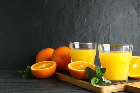 切板与橙汁薄荷和橙子在黑色背景的木桌上图片
