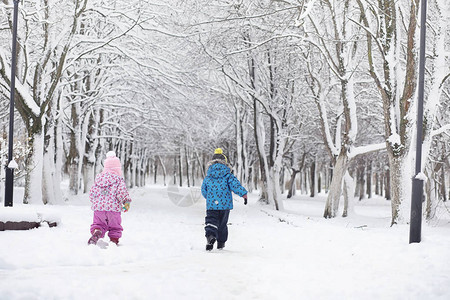 白雪覆盖的冬季公园和长椅公园和码头喂子和鸽子一家人在雪地里散步图片