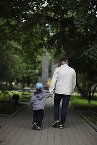 爷和她的孙子在一个春天的公园里散步孙子和祖父在散步爷正在和一图片