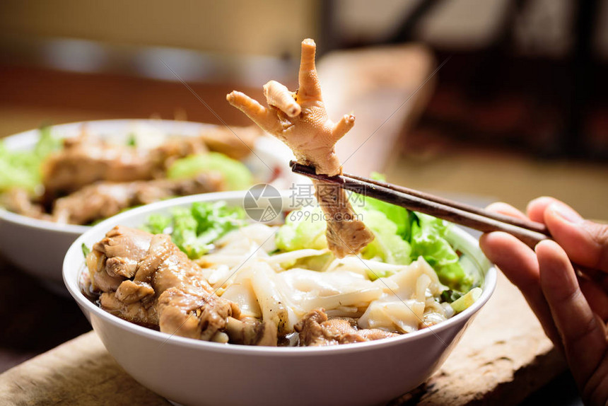 手拿筷子吃米粉汤炖鸡爪图片
