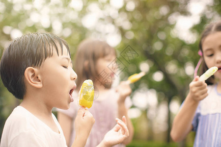 快乐的孩子们在夏天吃冰棒背景图片