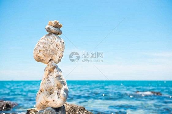 在石滩和海背景的禅宗石头平衡图片