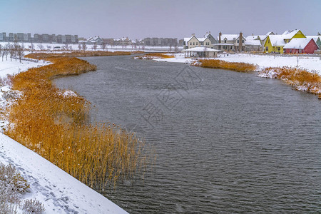 靠近白雪皑的湖岸和长满草的湖边的房屋图片