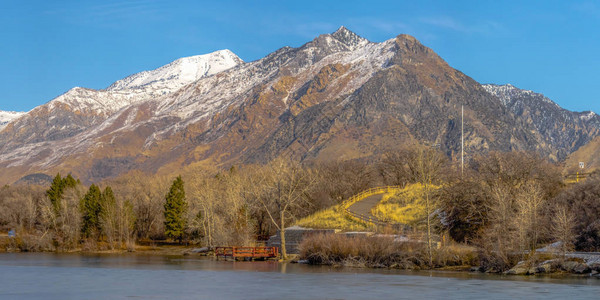 明亮的全景冰河湖和在冬季向充满活力的蓝色天空冲去的雪盖山峰图片