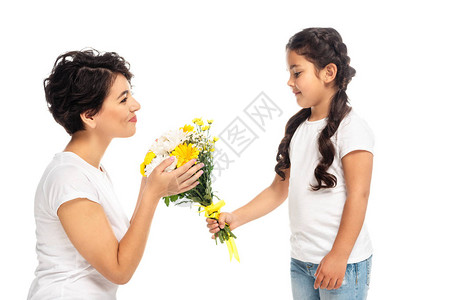 快乐的小孩送鲜花给有魅力的白衣母亲孤图片